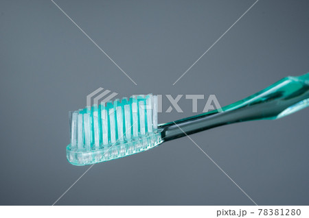 Green toothbrush on a gray background. Toothbrush isolate. Green toothbrush on a gray background. Toothbrush isolate. 78381280