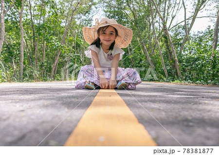 little girl sitting on the middle of asphalt road little girl sitting on the middle of asphalt road 78381877