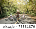 Mother and daughters walking in a park 78381879