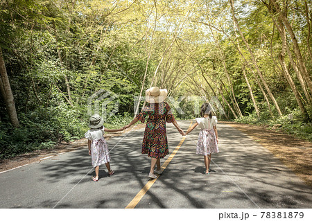 Mother and daughters walking in a park 78381879