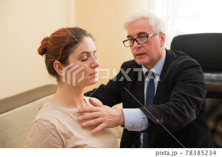 Mature gray-haired man hypnotizes Caucasian woman during hypnotherapy session. The psychologist uses alternative treatments for the subconscious mind Mature gray-haired man hypnotizes Caucasian woman during hypnotherapy session. The psychologist uses alternative treatments for the subconscious mind 78385234