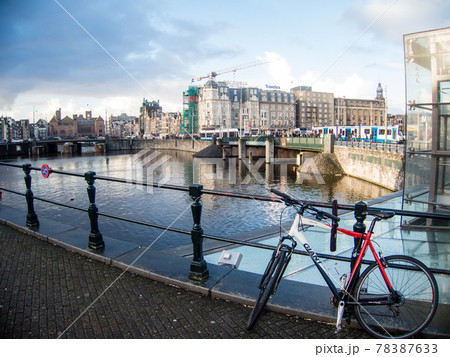 オランダアムステルダムの運河脇に止められた自転車と路面電車の走る街並み オランダアムステルダムの運河脇に止められた自転車と路面電車の走る街並み 78387633