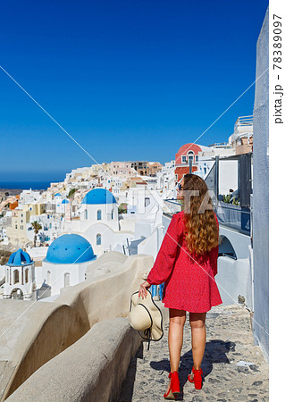 Young woman walks on the island of Santorini Young woman walks on the island of Santorini 78389097