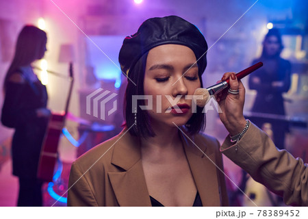 Hand of makeup artist applying powder on face of young woman Hand of makeup artist applying powder on face of young woman 78389452