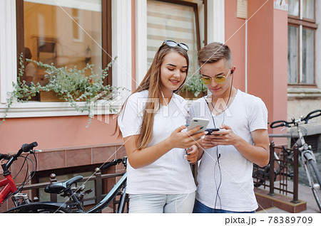 Couple standing in a city with mobile phone 78389709