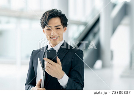 オフィスでスマホを操作するスーツ姿のビジネスマン 78389887