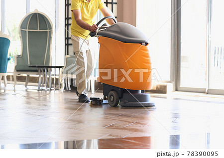 Man is cleaning hotel lobby with industrial vacuum cleaner 78390095