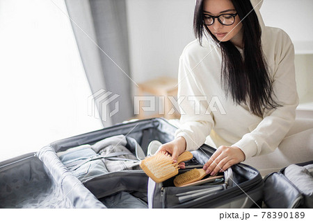 Focused woman making list packing suitcase organization. Clothes, cosmetic bag, case for equipment 78390189