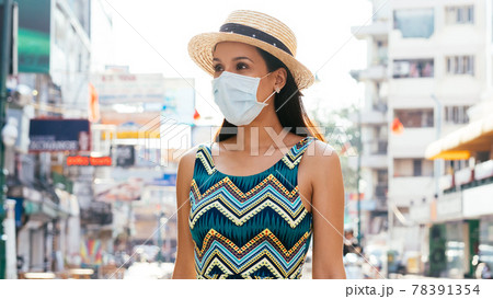 Young Mexican woman wearing face mask in city 78391354