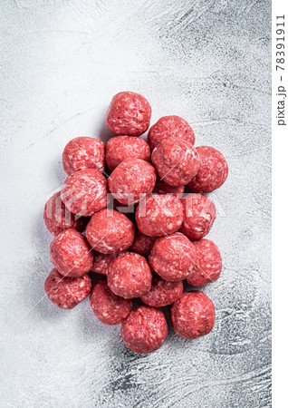 Raw beef and pork meatballs with spices on kitchen table. White background. Top view 78391911