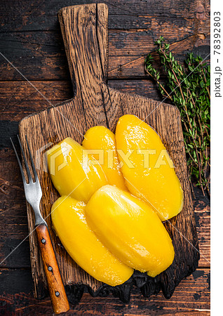 Preserve mango slices on a wooden board. Dark wooden background. Top view Preserve mango slices on a wooden board. Dark wooden background. Top view 78392803