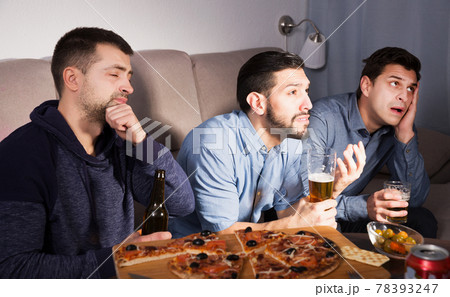 friends in suspense watching tv together at home friends in suspense watching tv together at home 78393247