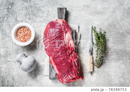 Fresh Flank or flap raw beef steak on wooden board with herbs. Gray background. Top view Fresh Flank or flap raw beef steak on wooden board with herbs. Gray background. Top view 78398753