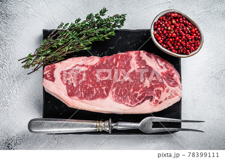 Raw striploin or new york strip steak on a marble board. White background. Top view 78399111