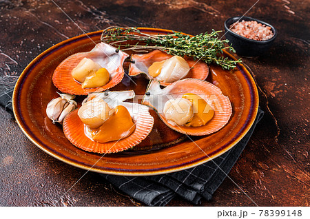 Shellfish raw Scallops on a rustic plate with thyme. Dark background. Top view 78399148