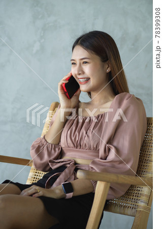 Female office worker talking on the phone while relaxed sitting in cafe 78399308
