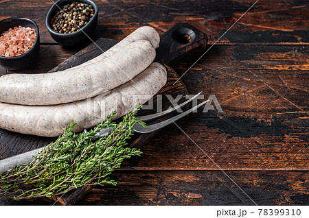 Munich traditional white sausages on a wooden board with thyme. Dark wooden background. Top view. Copy space 78399310