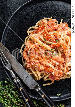 Feta pasta with Oven baked cherry tomatoes on a plate. Black background. Top view 78399348