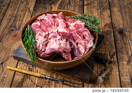 Boneless raw mutton Lamb Shoulder meat in wooden plate with herbs. wooden background. Top view 78399540