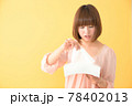 つらそうな顔でティッシュボックスからティッシュを取り出す若い女性 78402013