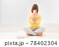床に座りティッシュで鼻をかむ辛そうな顔の若い女性 78402304