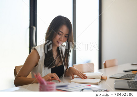 Young asian woman designer sitting in creative office and making noet on notebook. 78402380