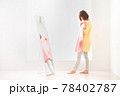 ピンク色のボーダー柄の洋服を鏡の前で体に合わせてみる若い女性 78402787