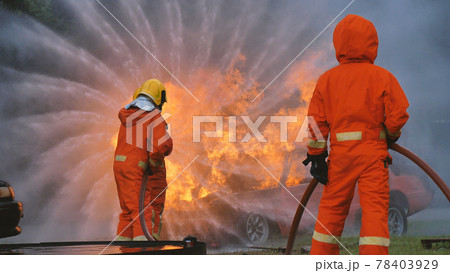 Firefighter fighting with flame using fire hose chemical water foam spray engine. Fireman wear hard hat, body safe suit uniform for protection. Rescue training in fire fighting extinguisher Firefighter fighting with flame using fire hose chemical water foam spray engine. Fireman wear hard hat, body safe suit uniform for protection. Rescue training in fire fighting extinguisher 78403929