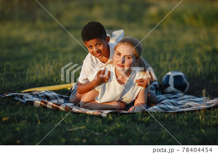Multi-racial family playing in a summer park Multi-racial family playing in a summer park 78404454