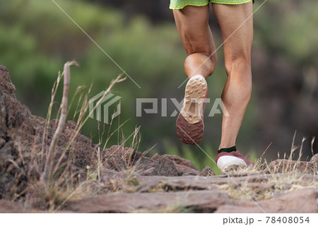 Athlete trail running in the mountains on rocky terrain, sports shoes detail 78408054