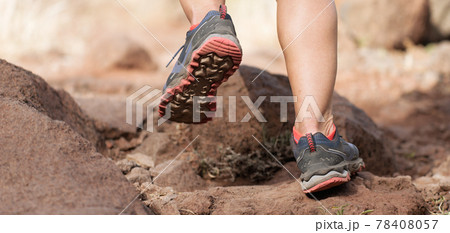 Athlete trail running in the mountains on rocky terrain, sports shoes detail 78408057