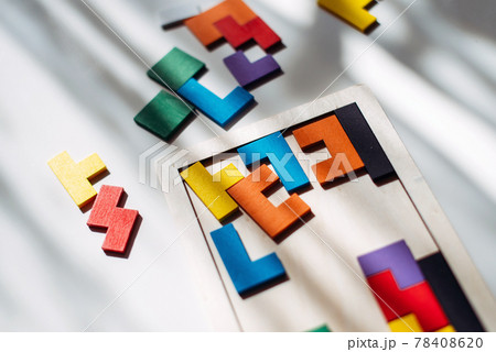 Wooden colored puzzle lies scattered on the table 78408620
