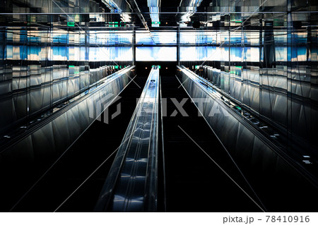Abstract dark scene of escalators with bright display screen. 78410916