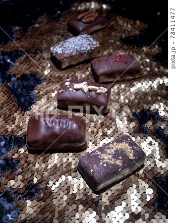 Assorted dark handmade chocolate on the sequins Assorted dark handmade chocolate on the sequins 78411477