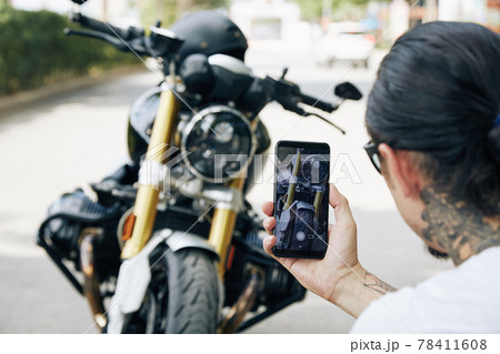 Man taking photos of motorcycle Man taking photos of motorcycle 78411608