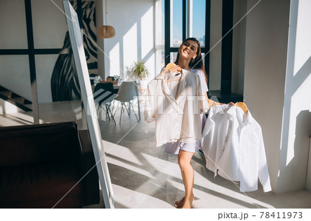 Beautiful girl trying dress in room 78411973