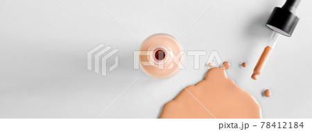 Banner with Mockup glass bottle of correction cosmetic product with pipette. Spilled Liquid foundation. Beauty branding concept 78412184