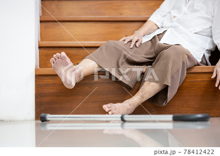 Old elderly lies unconscious on the floor of the staircase after slipping,tripping or losing balance while walking,moving with difficulty,senior woman fell down the stairs,an accident in the house 78412422