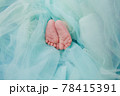 Baby's feet under a green blanket 78415391