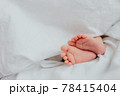 Baby's feet under a white blanket 78415404