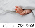 Baby's feet under a white blanket 78415406