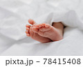 Baby's feet under a white blanket 78415408