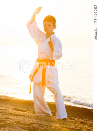 Boy practising karate at seaside 78416202