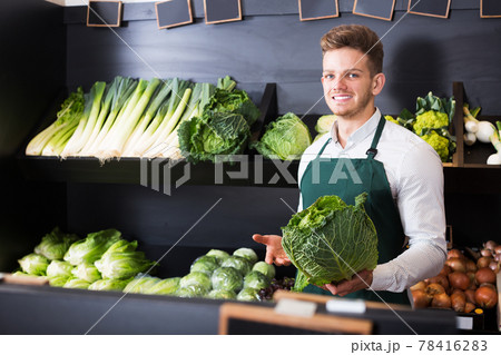 Seller showing cabbage in shop Seller showing cabbage in shop 78416283