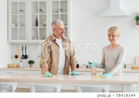Positive couple doing household chores together, talk and enjoy spare time at covid-19 78419344
