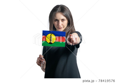 Happy young white woman holding flag of New Caledonia and points forward in front of him isolated on a white background Happy young white woman holding flag of New Caledonia and points forward in front of him isolated on a white background 78419576