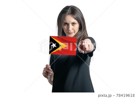 Happy young white woman holding flag of East Timor and points forward in front of him isolated on a white background 78419618