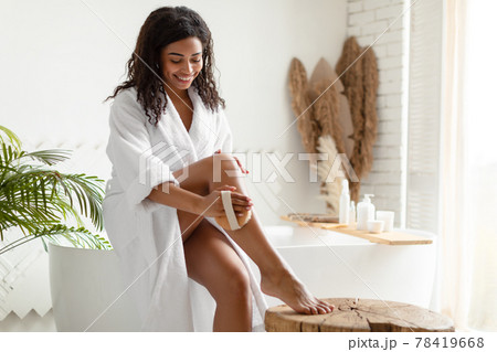 African Lady Dry Brushing Legs Using Massage Brush In Bathroom 78419668