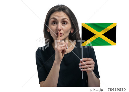 Happy young white woman holding flag of Jamaica and holds a finger to her lips isolated on a white background Happy young white woman holding flag of Jamaica and holds a finger to her lips isolated on a white background 78419850