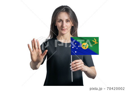 Happy young white woman holding flag of Christmas Island and with a serious face shows a hand stop sign isolated on a white background 78420002